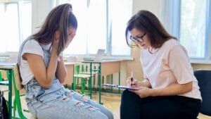 A teen with depression speaks to a therapist.