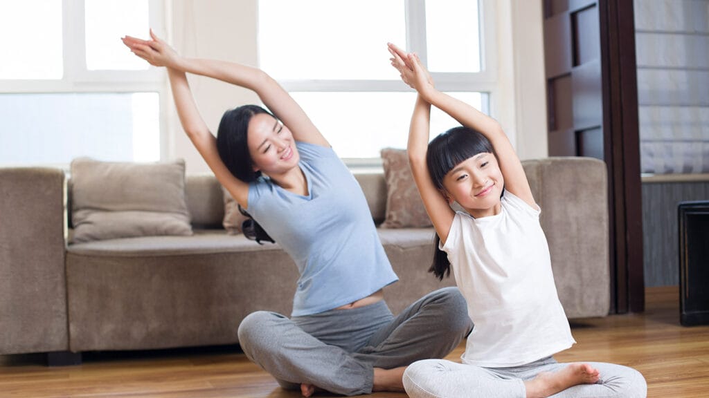 Mother and young daughter do Yoga.