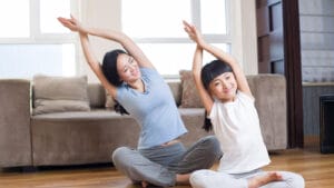 Mother and young daughter do Yoga.