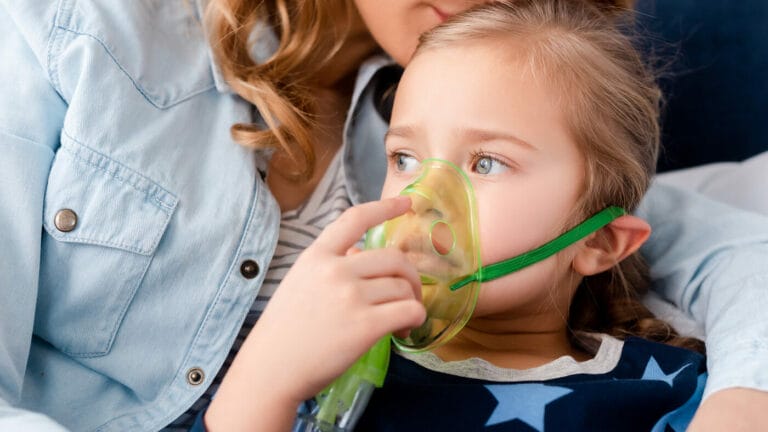 An ill child wears a respiratory mask.