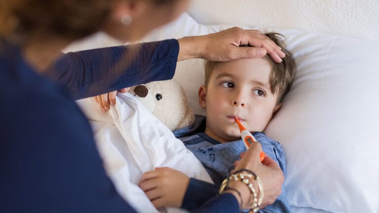 A mother checks her son for fever.