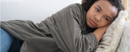 Depressed teen laying on couch