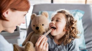 Doctor checks little girl for strep throat.