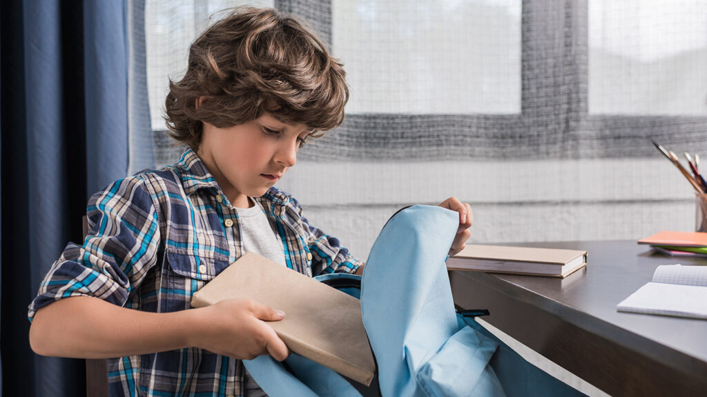anxious child packing his backpack for school