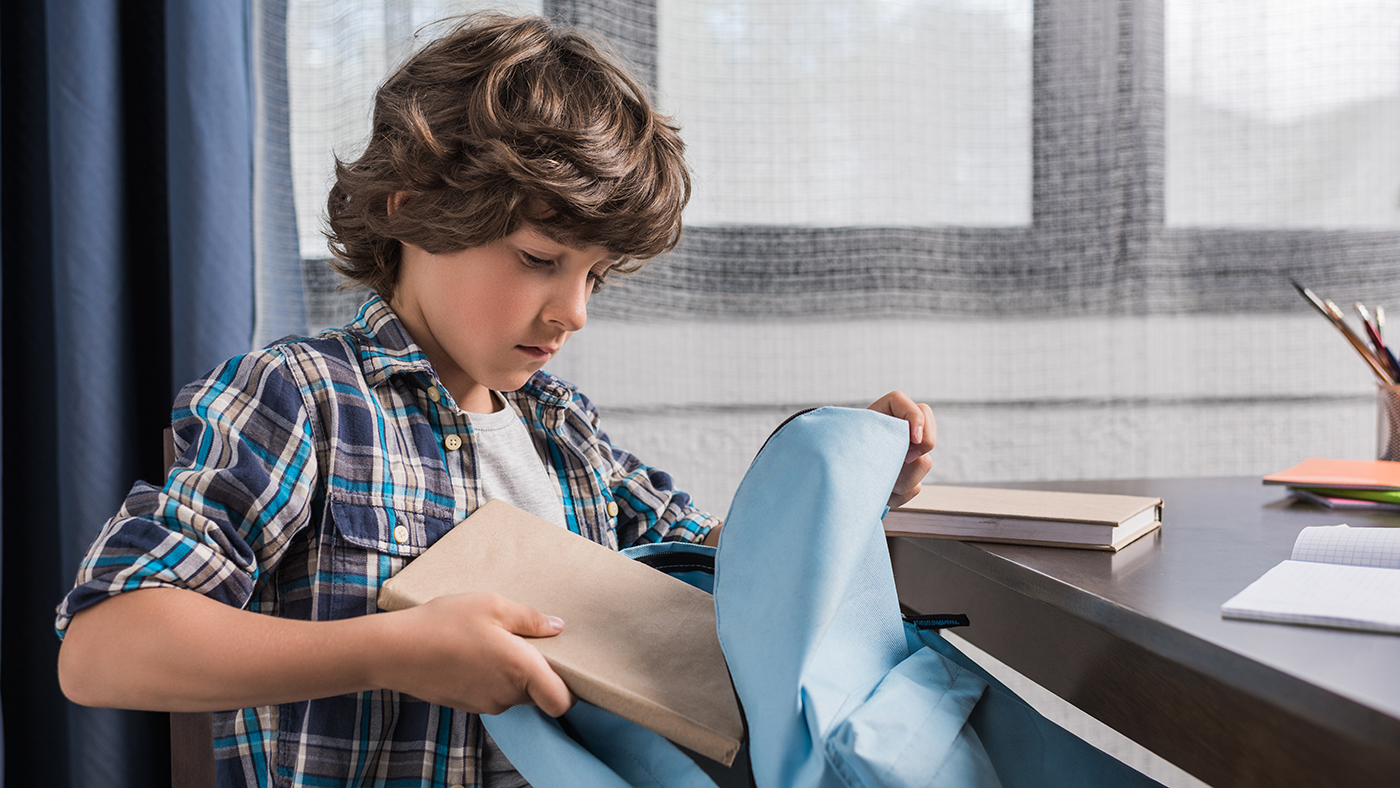 anxious child packing his backpack for school
