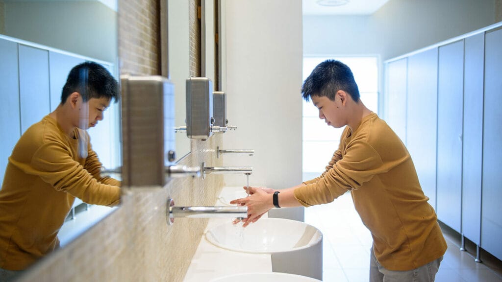 A boy washing his hands.