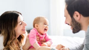 Mother and Father laugh with baby.