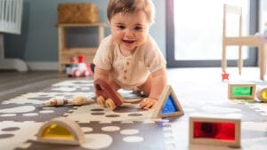 Baby playing with colorful toys on a play mat