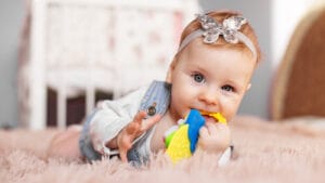 Baby girl chewing on a teething toy