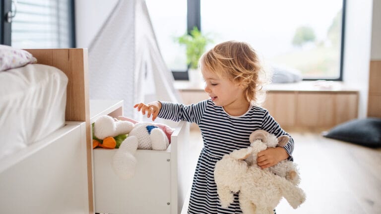 Toddler putting away toys