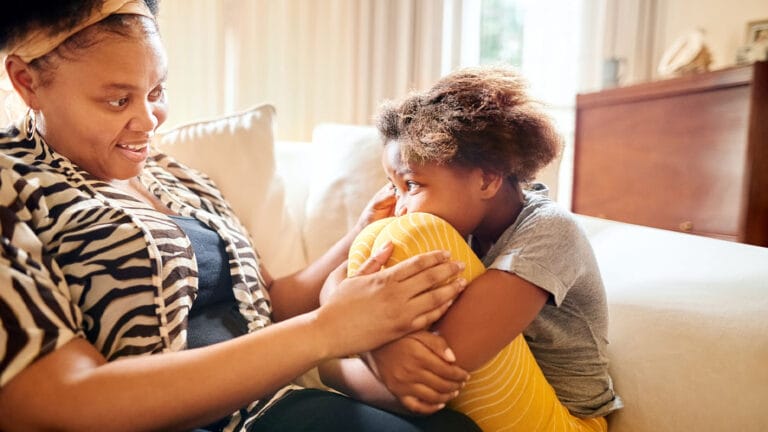 Mother and daughter talking on couch