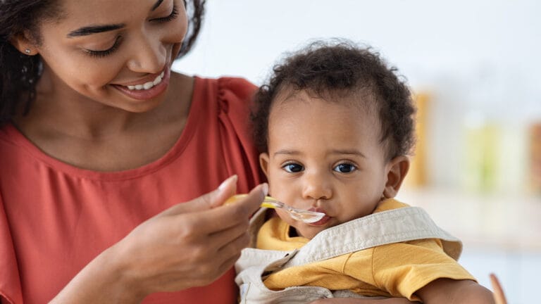 Mom feeding baby solid foods with a spoon