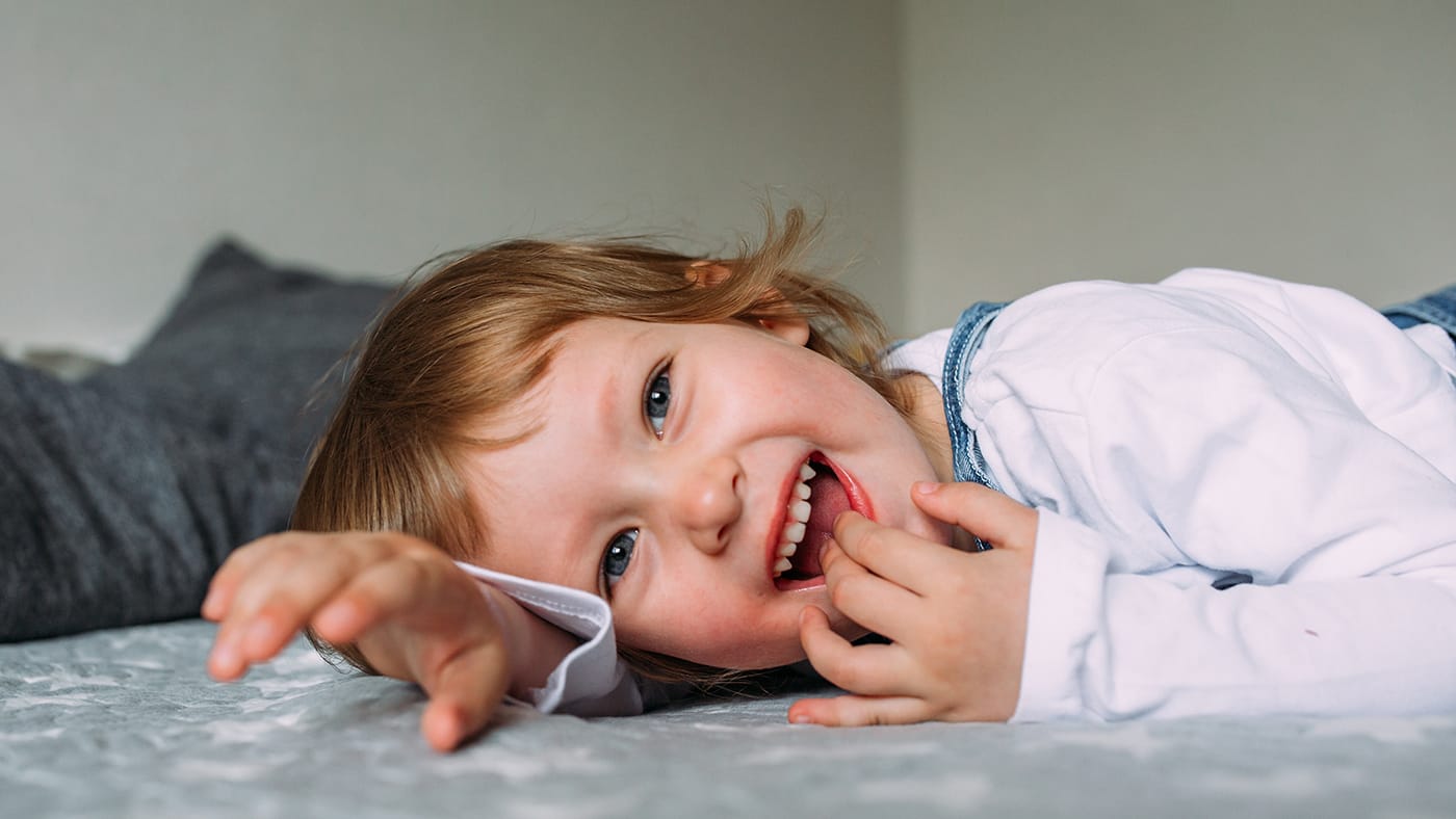 toddler laying on the best smiling.