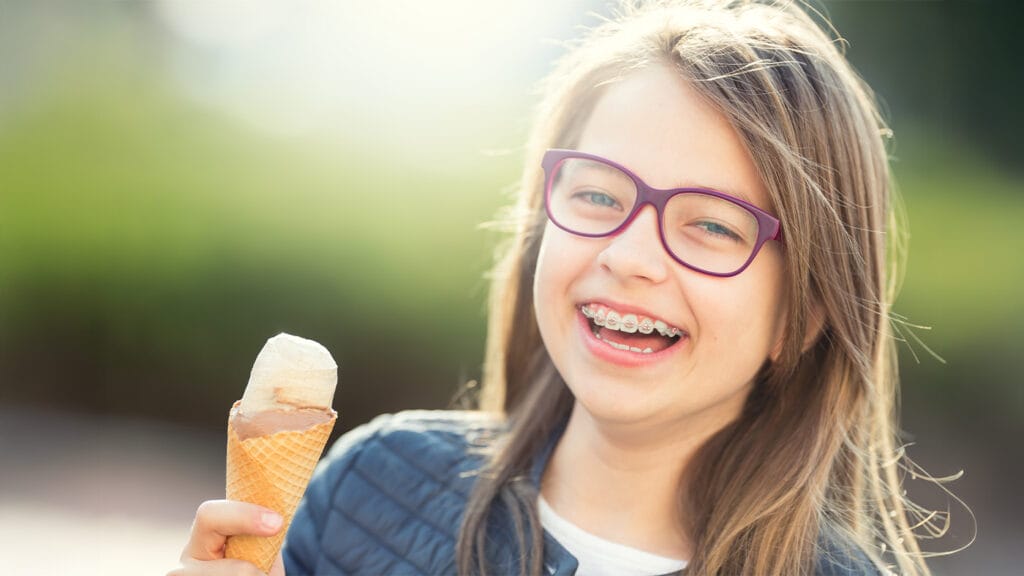 Young girl with braces eating ice cream