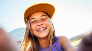Young girl flashing bright smile with braces