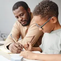 A child doing homework with his father