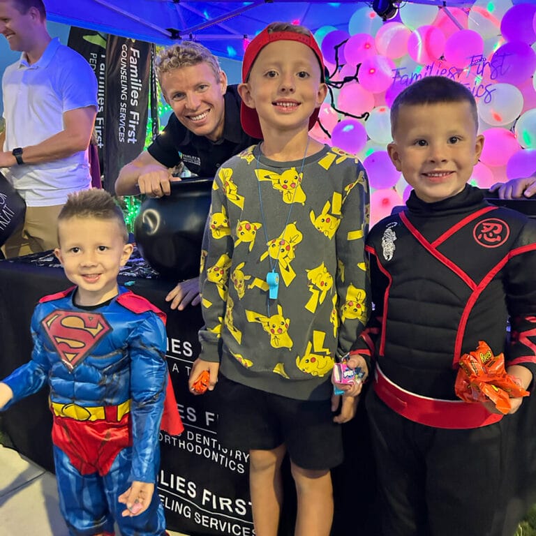 Three children smiling with a Families First provider