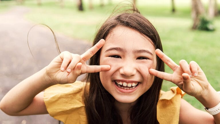 close up of a happy, young asian girl in the park smiling