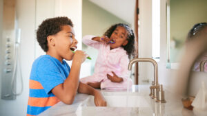 Siblings brushing their teeth together in the bathroom
