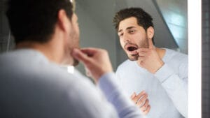 young dad looking in the mirror at his dental work