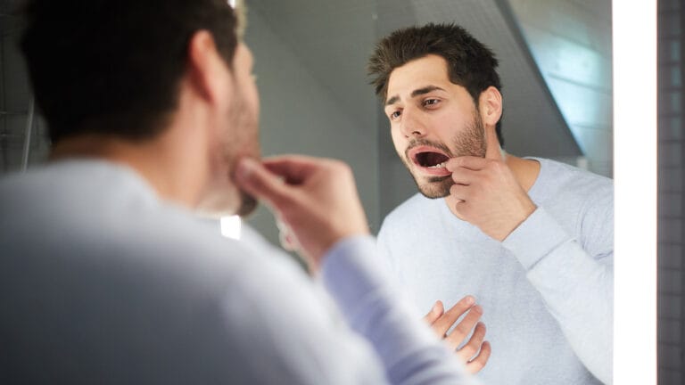 young dad looking in the mirror at his dental work