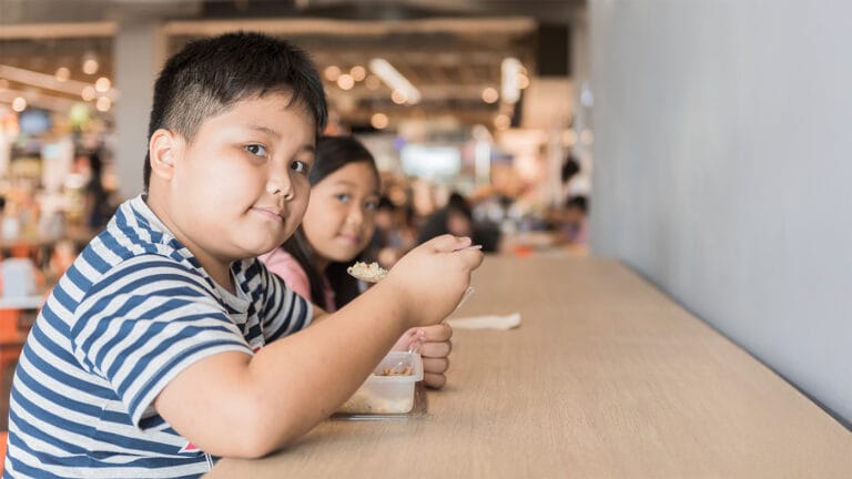 Overweight siblings sitting together for a meal