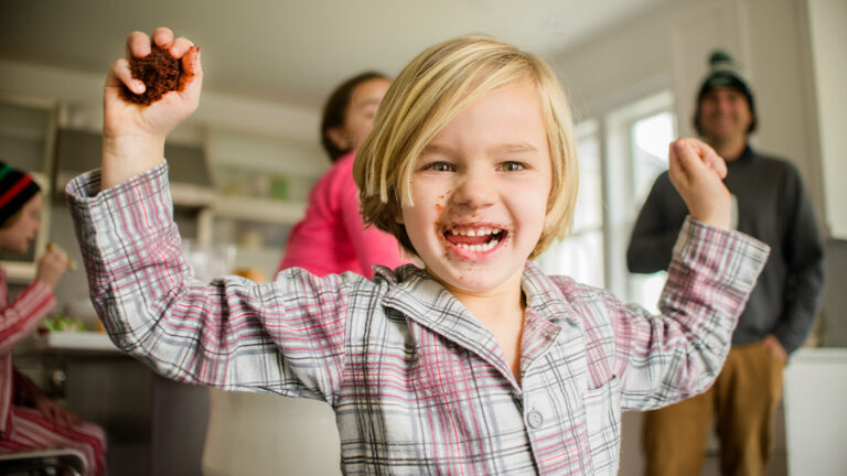Young child with cake in hand and running around