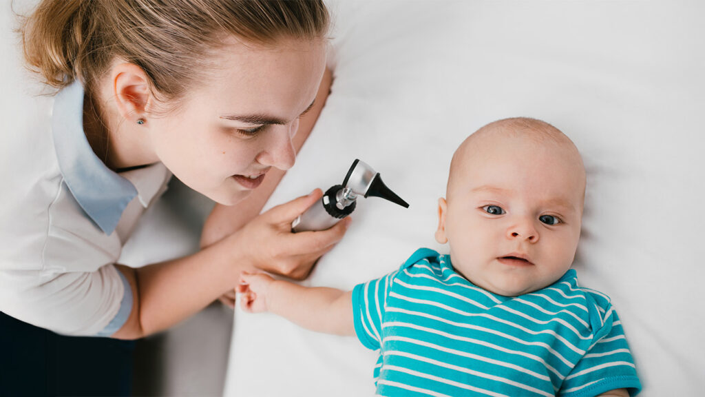 Pediatrician looking at baby's ear