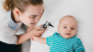 Pediatrician looking at baby's ear