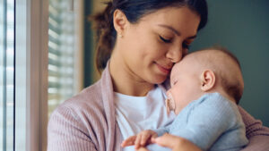 mom holding sleeping baby with a flat head