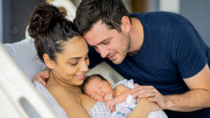 new dad and mom with newborn in the hospital having skin to skin