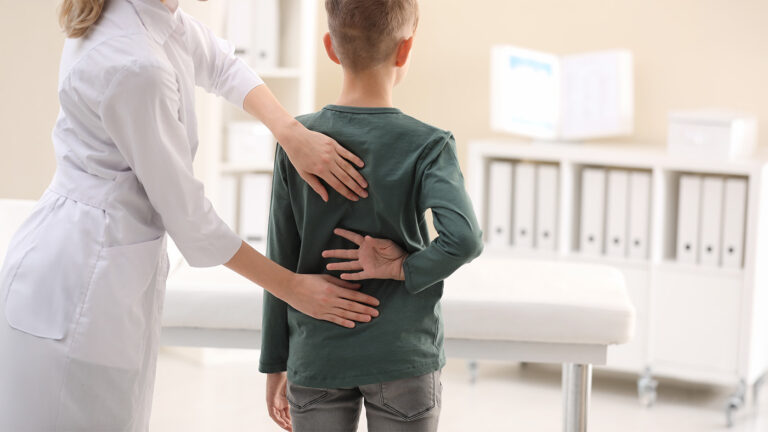 Young boy having his back examined by a chiropractor