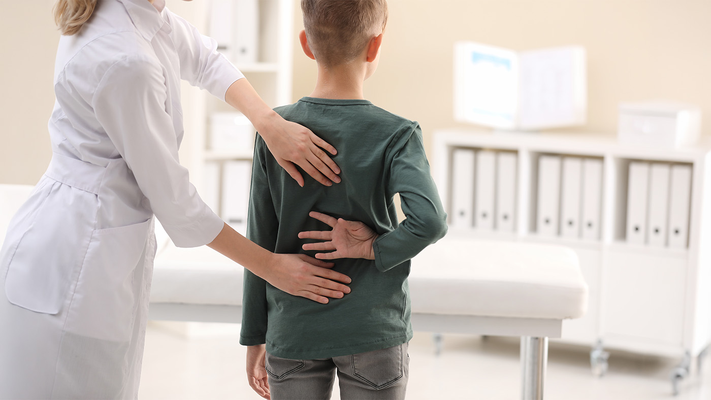 Young boy having his back examined by a chiropractor