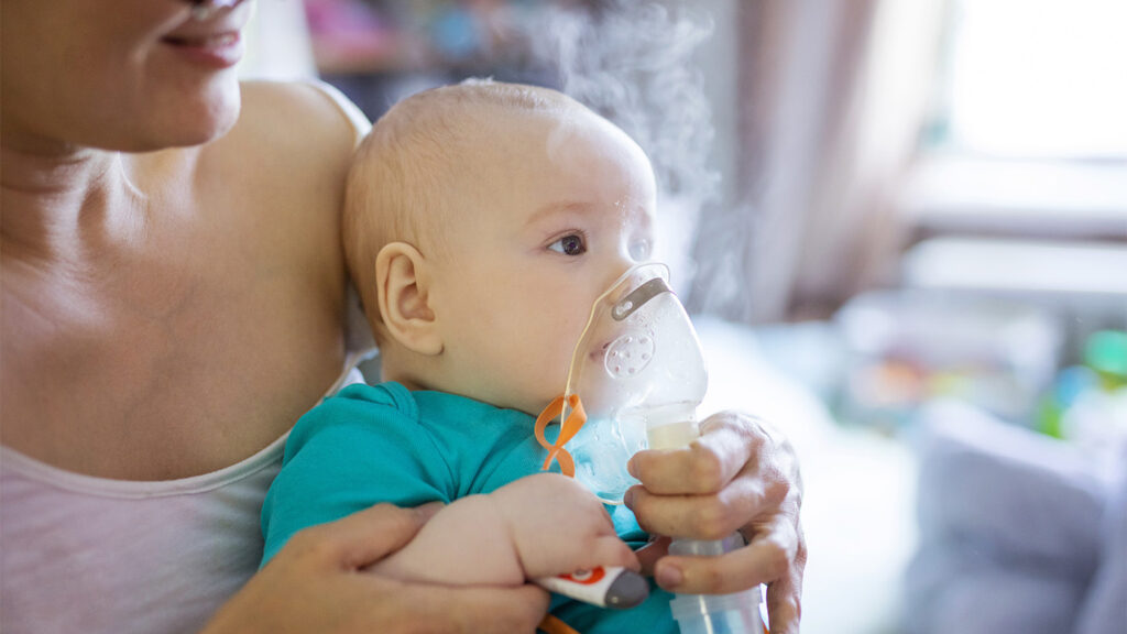 Mother helping her baby breathe with an oxygen mask