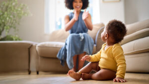 Young mother clapping for her baby saying their first word.