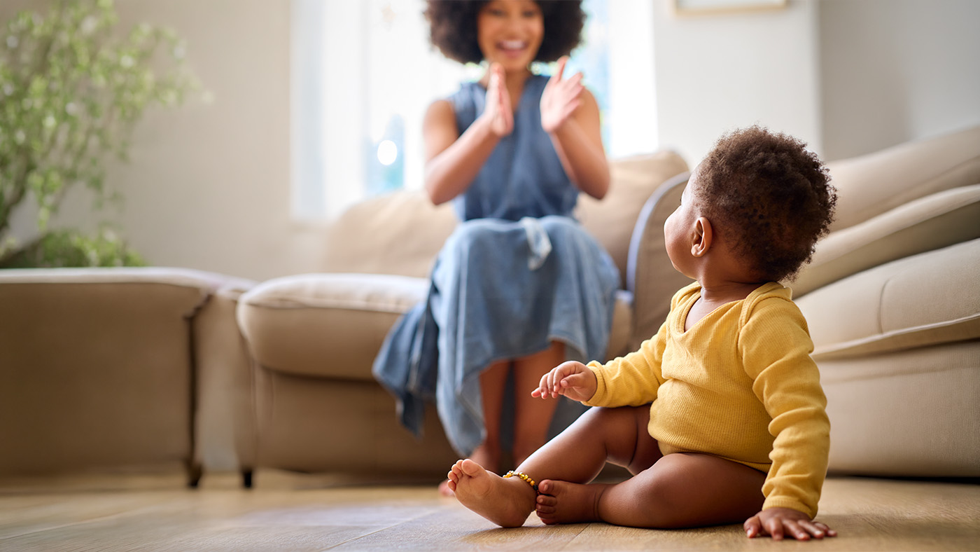 Young mother clapping for her baby saying their first word.