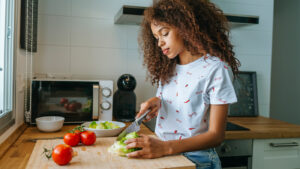 Young woman cutting vegetables on a cutting board